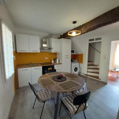 une cuisine et une salle à manger avec une table et des chaises dans l'établissement Le petit gîte de Rosalie, à Blauvac