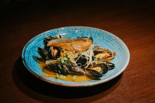 a blue bowl of food with mussels and meat at Redesdale Arms Hotel in Moreton in Marsh