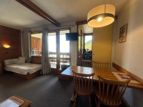 - un salon avec une table à manger et un lit dans l'établissement Studio divisible fonctionnel · Ski aux pieds - FR-1-181-2688, à La Plagne Tarentaise