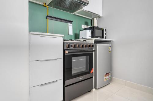 a kitchen with a stove and a microwave at Spacious Studio With Dubailand Charm in Dubai