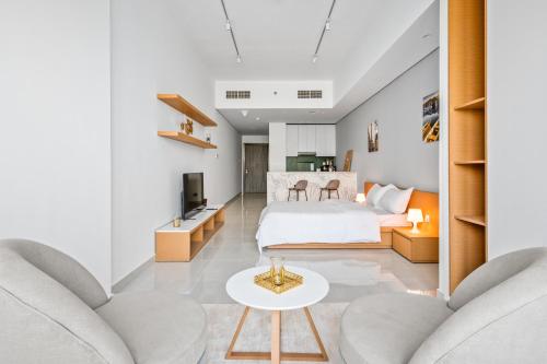 a bedroom with a bed and a living room at Spacious Studio With Dubailand Charm in Dubai