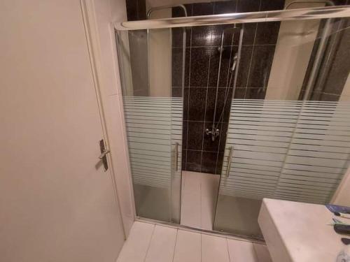 a shower with a glass door in a bathroom at The view IVI in Umm Uthainah