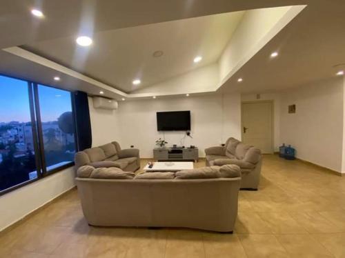 a living room with two couches and a flat screen tv at The view IVI in Umm Uthainah