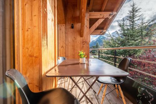- un balcon en bois avec une table et des chaises en bois dans l'établissement ETOILE Appartement 5 chambres , centre de Morzine, à Morzine