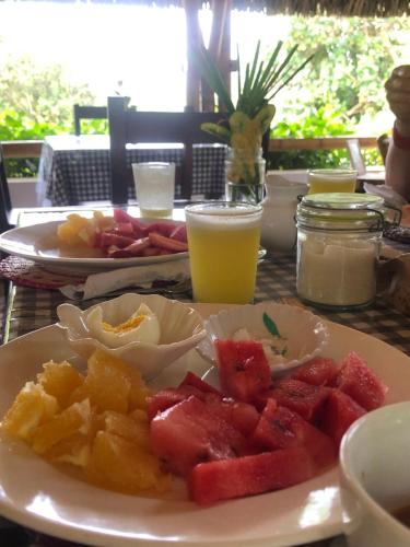 a table with a plate of watermelon and fruit on it at Hostal Los Orishas in Ayampe