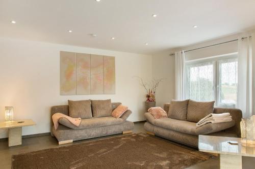 a living room with two couches and a table at Pur Wohnen- Wohnung Ost in Bad Griesbach