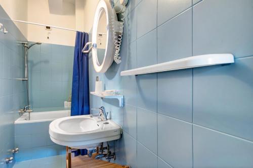 a blue bathroom with a sink and a mirror at Appartamento Bilocale Moneglia 21 in Moneglia