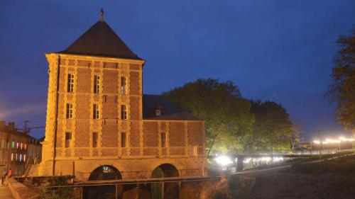 a large building with a clock tower at night at Olivine , Chaleureuse & cocooning in Bogny Sur Meuse
