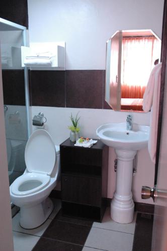 a bathroom with a toilet and a sink at Manila Manor Hotel in Manila