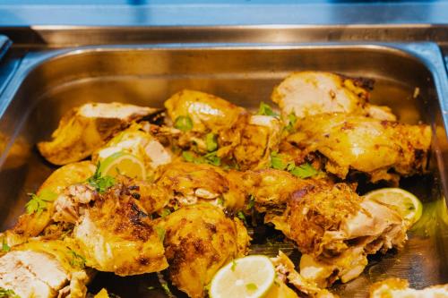 a metal pan of food with chicken and vegetables at Nahrawess Resort & Thalasso in Hammamet
