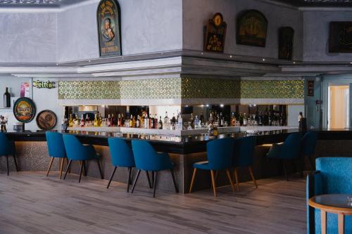 a bar in a restaurant with blue chairs at Nahrawess Resort & Thalasso in Hammamet