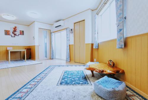 a room with a table and a rug at ABC Guest House 2F in Izumi-Sano