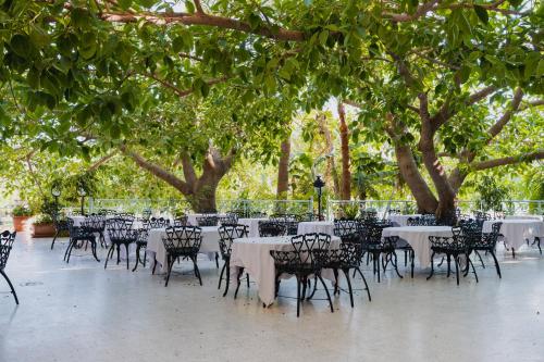 a group of tables and chairs under some trees at Nahrawess Resort & Thalasso in Hammamet