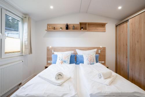 a bedroom with two beds with white sheets and pillows at Ostseecamp Ferienhaus "Pier 99" in Scharbeutz