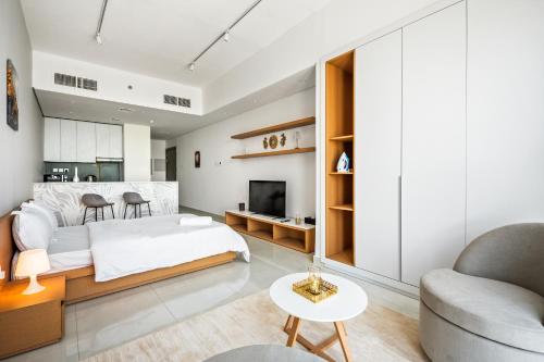 a bedroom with a bed and a living room at Bright Studio In Vibrant Dubailand District in Dubai
