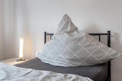 a large white pillow sitting on top of a bed at Gemütliche Wohnung Buchholz i d N in Buchholz in der Nordheide