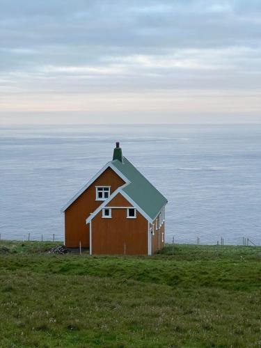 a red barn sitting on top of a grass field at The Yellow House By The End Of Suuroy in Sumba
