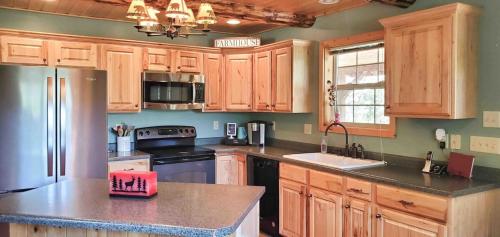 a kitchen with wooden cabinets and a black refrigerator at Virgin River Retreat East Zion & Bryce in Glendale