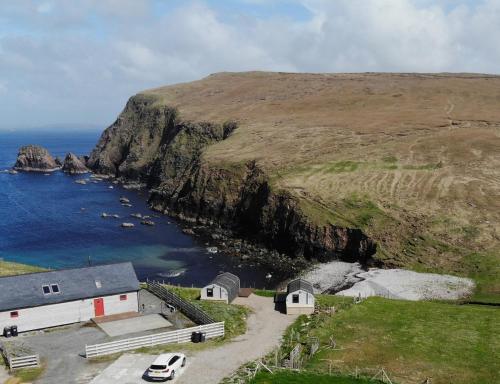 a church on a cliff next to the ocean at SEApods - Isle of Lewis - Luxury en-suite pods on the edge of the Atlantic Ocean in Aird Uig