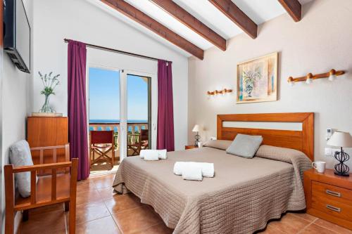 a bedroom with a large bed and a balcony at Villa Proa by Villa Plus in Alaior