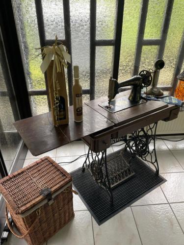 a table with two bottles of wine and a basket at DeNi's Ferienwohnungen in Klotten