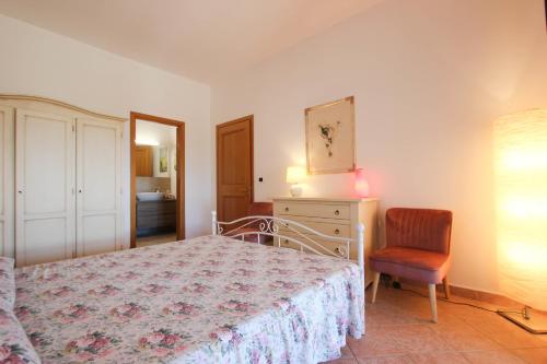 a bedroom with a bed and a chair and a dresser at Appartamento Villa Poggio La Leona in Cerbaia