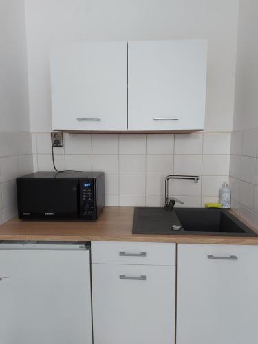 a kitchen with a microwave and a sink at Silver Dream Apartmanház in Debrecen