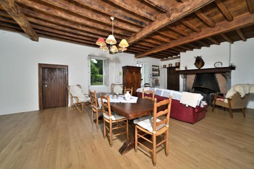 a dining room with a table and a fireplace at La maison Bayle in Mauvezin
