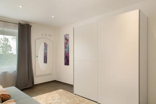 a living room with a large white cabinet at Pur Wohnen- Wohnung Ost in Bad Griesbach