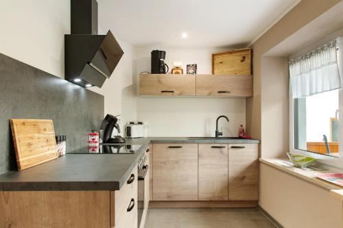 a kitchen with wooden cabinets and a sink at Pur Wohnen- Wohnung Ost in Bad Griesbach