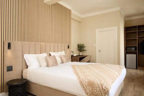 a bedroom with a large white bed with white pillows at Hotel Bruxelles in Cape Town