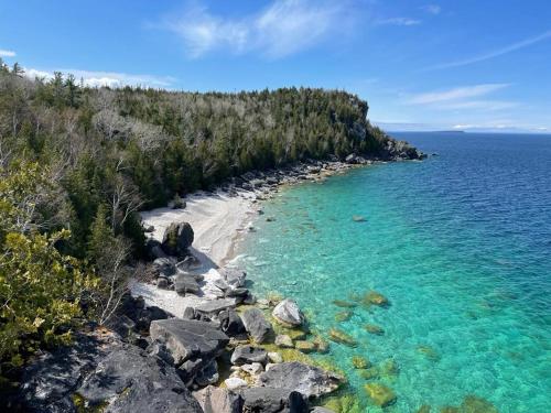 a beach with a bunch of rocks and water at Georgian Legendary Tobermory Retreat With Hot Tub in Tobermory