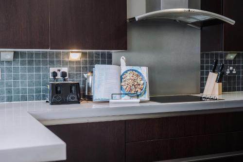 a kitchen counter with a plate of pasta on it at Pass the Keys Central Altrincham 2Bed Apartment in Altrincham