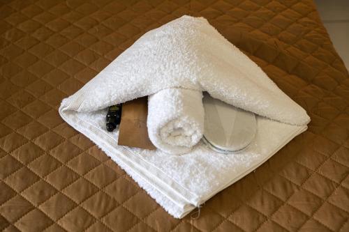 a towel on a bed with a cup and a mirror at Villa Costa Luca in Vouliagmeni in Athens