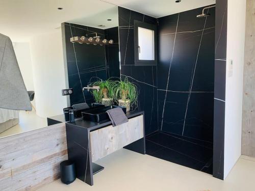 La salle de bains noire est pourvue d'un lavabo et d'une douche. dans l'établissement Magnifique villa de 220m2,piscine,vue mer, à Cagnes-sur-Mer