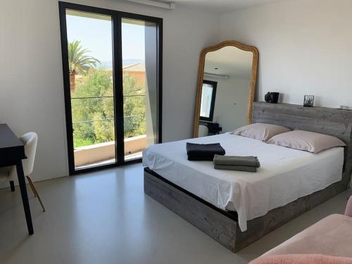 une chambre avec un grand lit et un miroir dans l'établissement Magnifique villa de 220m2,piscine,vue mer, à Cagnes-sur-Mer