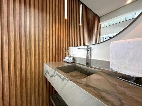a bathroom with a sink and a mirror at Grand Lux House Barra São Miguel Hosti Hospedagens in Barra de São Miguel