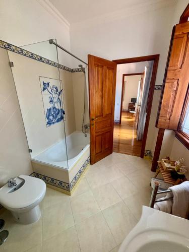 a bathroom with a shower and a toilet and a tub at Casa da Villa 1B in Sintra