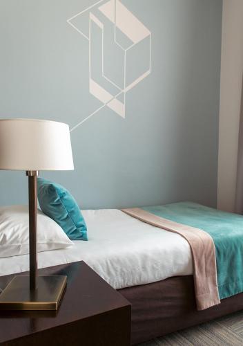 a bedroom with a bed with a table with a lamp at Europeum Hotel in Wrocław