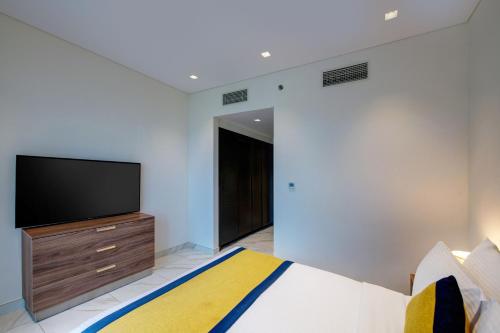 a bedroom with a bed and a flat screen tv at SUHA Mina Rashid Hotel Apartments in Dubai