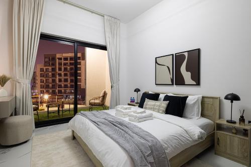 a bedroom with a large bed and a large window at Brand New 1BR with Pool, Sauna & Gym in Dubai