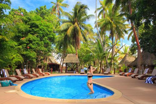 kobieta w bikini stojąca przed basenem w obiekcie Toberua Island Resort w mieście Toberua