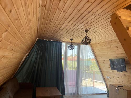 a room with a large window in a wooden ceiling at Demetra in Buknari