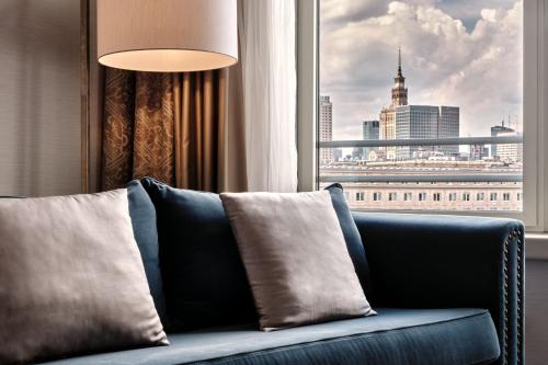 a couch in a room with a view of a city at Sheraton Grand Warsaw in Warsaw