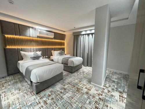 a hotel room with two beds in a room at Sweet Land Hotel in Umm Lujj