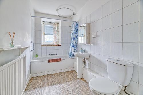 a white bathroom with a toilet and a sink at Bridge End Mill by Guestz in Settle