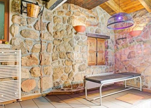 a stone wall with a bench in a room at Abantos LA CASA DE GALAPAGAR in Galapagar