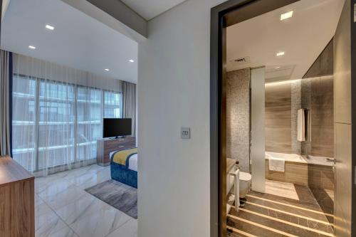 a hotel room with a bed and a bathroom at SUHA Mina Rashid Hotel Apartments in Dubai