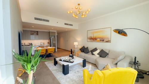 a living room with a couch and a table at Luxury 2 Bedroom Poolside Haven in Dubai Creek Harbour in Dubai