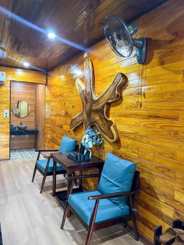 a dining room with a wooden wall with a table and chairs at Tam Coc Central Bungalow-Hostel in Vũ Lâm